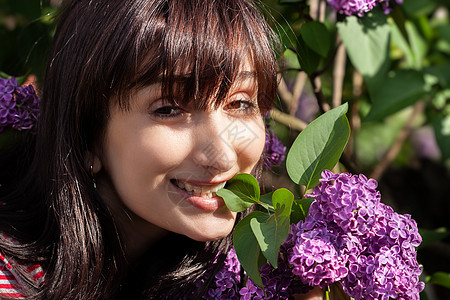 女人在开阔的花边上装饰丁香花公园紫丁香花朵季节阳光灌木丛女士衬套头发图片