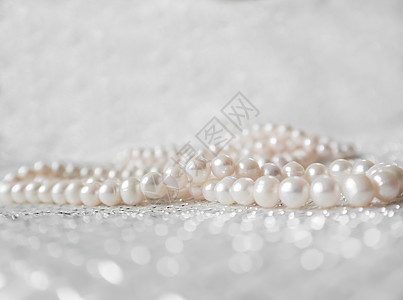 闪闪发光的背景上的天然白色珍珠串 焦点柔和 亮点突出奢华珍珠宝石学闪光矿物地质学财富珠宝问候语魅力图片
