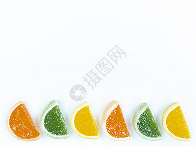多色橘子柑橘片在白色背景的糖面上 有复制空间图片