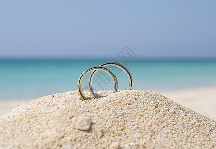 热带海滩沙沙滩上的对等结婚戒指珠宝首饰地平线布置夫妻婚姻结婚日沙漠支撑天堂图片