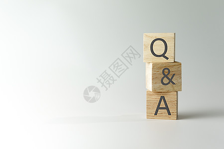 在木制立方体上 用有背景的手握着Q和字母表 问答的含义帮助测验学习社区问题教育教学知识解决方案顾客图片