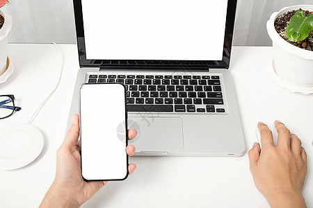 使用手持黑智能手机空白屏幕的手坐工作空间的女性桌子展示商业手指药片金子小样女士键盘细胞图片