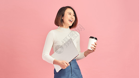 年轻美女喝着咖啡 手持剪贴板的美少女 与粉红背景隔绝图片