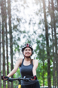 美丽的年轻女青年女子头盔活动单车森林微笑成人娱乐女孩骑术女性乐趣闲暇自行车图片