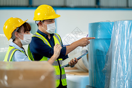 两名穿着安全制服的工厂工人男女在仓库中一起工作 检查产品并在工业企业的收集和转移过程中进行讨论图片