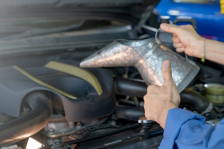 停车场工人或技术员在维修期间或在工作场所解决问题时 当车前握着一桶机油或润滑油的拇指贴近了手脚图片