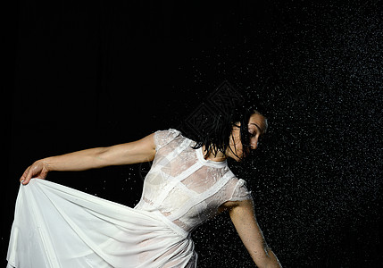 美丽的白种人长发黑发女人在黑色背景的水滴中跳舞 这位女士身穿白色雪纺连衣裙薄纱舞蹈头发运动姿势演员行动舞蹈家成人裙子图片