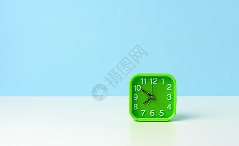 清晨10分钟到8点 白桌子上有白数字的绿色正方圆绿钟图片
