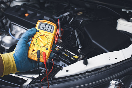 技术员用数字多米检查汽车电池的DC电压稳定区电压图片