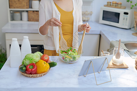 厨房做菜和使用平板板板的女子小样烹饪女士药片女性蔬菜互联网食物沙拉桌子背景图片