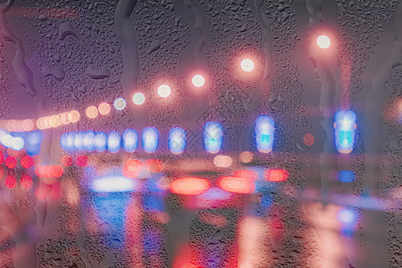 夜城的湿沥青在雨天窗户后面反射 这些灯光闪烁着汽车和灯笼圆圈天气交通夜生活运输雨滴运动街道场景城市图片
