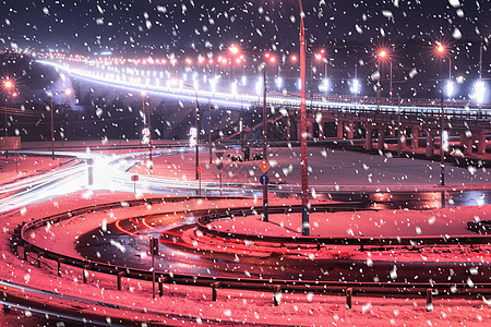 冬季晚上在大桥的雪瀑上行驶的汽车头灯的痕迹 湿沥青中的灯光反射运动踪迹夜景速度城市交通灯笼车辆运输辉光图片