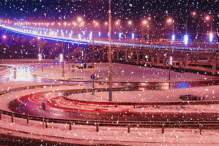 冬季晚上在大桥的雪瀑上行驶的汽车头灯的痕迹 湿沥青中的灯光反射夜景灯笼市中心驾驶踪迹交通街道速度景观辉光图片
