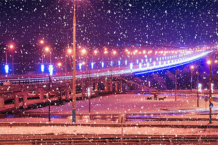 冬季晚上在大桥的雪瀑上行驶的汽车头灯的痕迹 湿沥青中的灯光反射景观城市踪迹速度驾驶运动市中心车辆运输街道图片