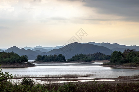 在日出或日落时 湖岸的景色与山脉在背景中自然景观风景爬坡场景蓝色天空森林城市娱乐旅行图片