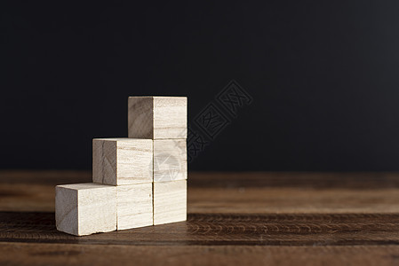 把堆叠的木制立方体装在桌子上投资小样立方体生产率竞赛棕色成就建筑战略信息图片