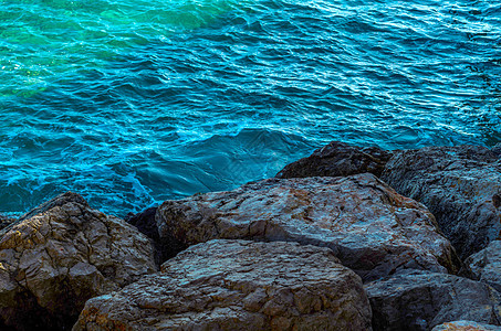 令人惊叹的海洋 有蓝色夏季波浪和岩石 对岩石和水的轻松透视美丽热带水晶旅游海湾太阳海岸边缘假期天空图片
