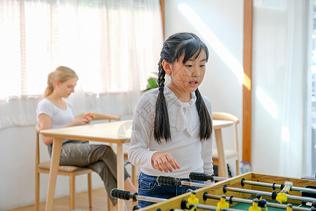 可爱的亚裔年轻女孩在课外课间休息时玩一些游戏 老师坐在她身后放松图片