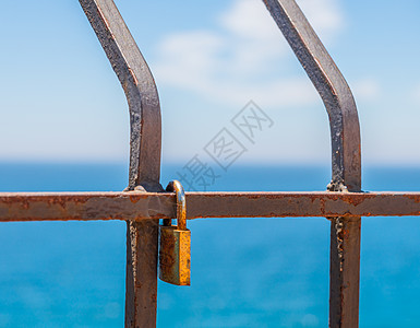 与海边的巴勒斯贸易相连的生锈挂锁 这是展示爱的传统方式订婚情人海岸友谊钥匙夫妻金属栅栏栏杆恋人背景图片