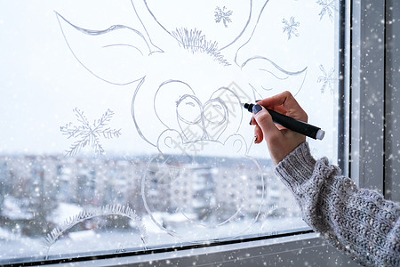 女手绘圣诞鹿画在窗玻璃上 窗户玻璃上的圣诞冬季装饰 鹿的白色图案 假日季节的雪花艺术窗饰窗驯鹿喷雪假期窗台动物女性绘画手工庆典幸图片
