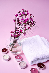 白棉毛巾 上面有粉红背景的细粉花和香蜡烛 SPA处理概念 复制空间图片