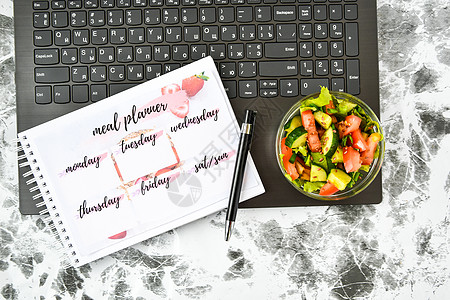 一周的膳食计划 在电脑附近的工作场所用蔬菜沙拉碗 工作间隙在办公室吃午饭时间小吃食物规划师键盘饮食学生笔记本健康饮食吃饭图片