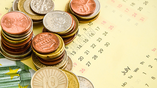 用于财务背景的日历上的硬币堆积 特写拍摄银行业贷款现金利润生长手表投资薪水预算货币图片