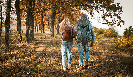 携着手背包的青年夫妇徒步旅行图片