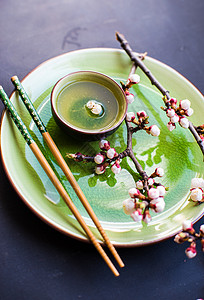 绿茶和桃花作为春季概念勺子筷子粉笔茶叶餐巾饮料树叶桌子杯子樱花图片