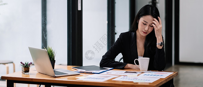 年轻的亚洲女商务人士在工作场所工作 编写营销报告 使用笔记本电脑制作Famle图片