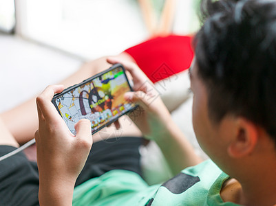手持智能手机在家玩游戏的亲手儿童图片