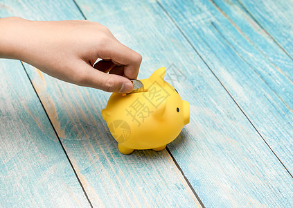 为了储蓄和金融概念 手把钱币存到小猪银行中图片