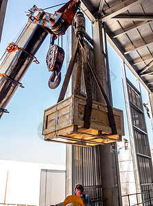 该起重机携带着一木箱放射性仪器持有者 放在工厂的顶层金属升降机机器工作服务工业货物运输装载机电缆图片