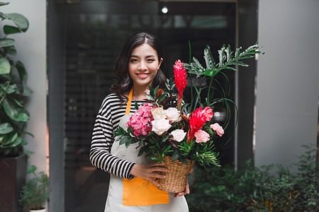 花店助理 提供一束鲜花红色店铺商业微笑花朵白色女士花束女性工作图片