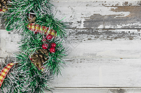 木制仿古背景平躺的圣诞花环 传统的圣诞花环 上面有红色浆果和装饰品 松果和木头上的棉花桌子乡村风格装饰假期松树卡片花圈锥体艺术图片
