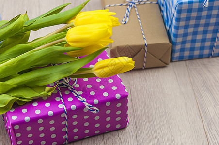 春郁金香花和送礼盒放在木桌上 欢迎妇女或母亲节树叶生日黄色桌子花束绿色乡村郁金香植物群丝带图片