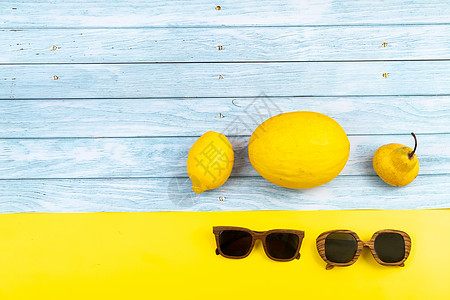 蓝色木质背景和黄色背景上放着各种黄色水果和眼镜甜点说谎热带季节食品椰子花园农业香瓜食物图片