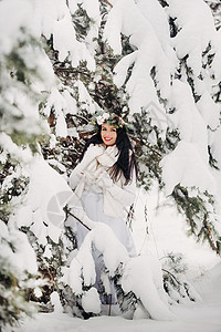 一个穿着白色衣服的女人在寒冷的冬天森林里的画像 在白雪覆盖的冬季森林里 头戴花环的女孩艺术新年假期季节帽子花园女士镜头木头雪花图片