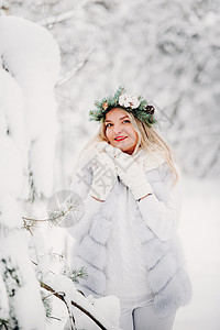 一个穿着白色衣服的女人在寒冷的冬天森林里的画像 在白雪覆盖的冬季森林里 头戴花环的女孩裙子新年帽子艺术季节雪花镜头花园女士木头图片