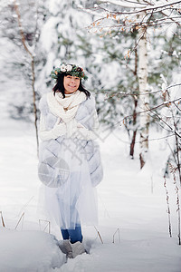 一个穿着白色衣服的女人在寒冷的冬天森林里的画像 在白雪覆盖的冬季森林里 头戴花环的女孩木头镜头花园帽子季节裙子艺术假期雪花新年图片