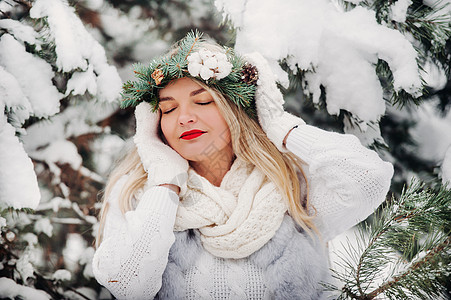 一个穿着白色衣服的女人在寒冷的冬天森林里的画像 在白雪覆盖的冬季森林里 头戴花环的女孩新年帽子镜头裙子季节艺术女士雪花花园假期图片