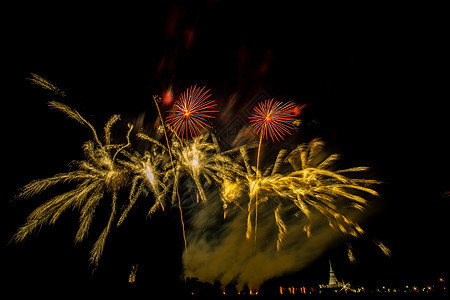 黄昏时在稻田上放着巨大的 多彩的烟火焰火假期黑色天空乐趣派对红色节日烟花庆典图片