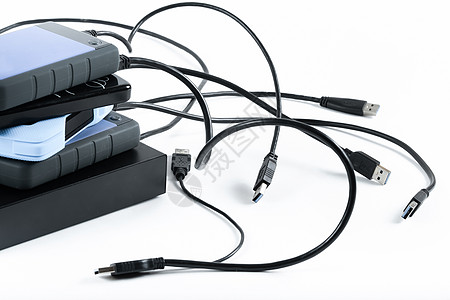 许多带有电线的外部硬驱动器位于白色背景 硬驱动器处于孤立状态桌子备份贮存电缆照片数据磁盘安全黑色硬盘图片
