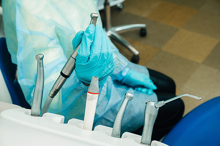 一名在牙科办公室戴手套的牙医工作前持有一种工具药品检查治疗钻头外科医院技术金属卫生医生图片