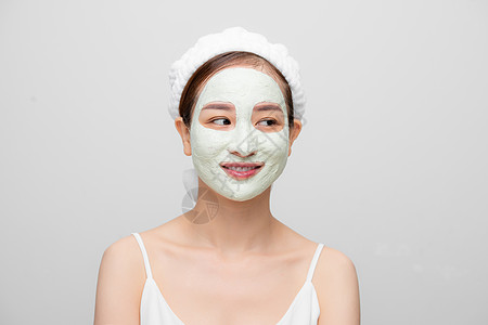 单独拍到的漂亮女人戴着面罩 用毛巾在白色背景上擦亮皮肤健康女士化妆品黏土护理温泉女性女孩润肤面具图片