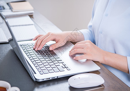商业概念 穿蓝衬衫的女士在电脑上打字 办公室桌上有咖啡 背光 太阳光亮效应 特写 侧视图 复制空间衬衫电话写作女性笔记本职场键盘图片
