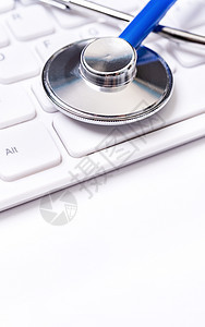 白桌背景的计算机键盘上的蓝色听诊器 在线医疗信息处理技术概念 特写 宏 复制空间GPS诊所考试听诊工具乐器医疗保险治疗医生服务医图片