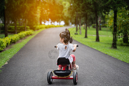 在花园里骑自行车的可爱婴儿公园平衡学习男生运动喜悦活动乐趣头盔三轮车图片