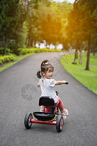 在花园里骑自行车的可爱婴儿平衡头盔男生玩具公园微笑活动喜悦运动学习图片