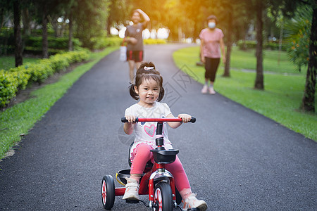 可爱的孩子们骑自行车 孩子们享受骑自行车家庭学习三轮车平衡头盔玩具后院乐趣女孩喜悦图片